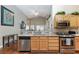 Bright kitchen features light wood cabinets, granite counters, stainless steel appliances, and wood flooring at 672 Hitchen Post Dr, Henderson, NV 89011