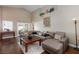 Spacious living room with high ceilings, hardwood floors, comfortable seating and French doors to backyard at 672 Hitchen Post Dr, Henderson, NV 89011