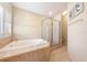 Bright bathroom featuring a tub with tiled surround and a glass-enclosed shower at 6860 Stubblefield Dr, Pahrump, NV 89061