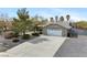 Front exterior featuring desert landscaping, a two-car garage, and a concrete driveway at 6860 Stubblefield Dr, Pahrump, NV 89061
