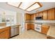 Charming kitchen with stainless steel dishwasher, tile countertops, and wood cabinets at 6860 Stubblefield Dr, Pahrump, NV 89061