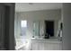 Bright bathroom features double sinks, a large mirror, and a separate tub with a window at 7022 Judith River St, North Las Vegas, NV 89084