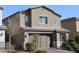 Home exterior exhibiting a brick driveway, manicured bushes, and a modern two-car garage at 7022 Judith River St, North Las Vegas, NV 89084