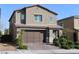 Home exterior exhibiting a brick driveway, manicured bushes, and a modern two-car garage at 7022 Judith River St, North Las Vegas, NV 89084