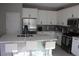 Modern kitchen featuring white cabinets, stainless steel appliances, and a marble countertop island with bar stool seating at 7022 Judith River St, North Las Vegas, NV 89084