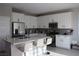 Bright kitchen with white cabinets, stainless steel appliances, and a marble countertop island with seating at 7022 Judith River St, North Las Vegas, NV 89084