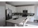Bright eat-in kitchen featuring white cabinets, a center island, and stainless steel appliances at 7022 Judith River St, North Las Vegas, NV 89084