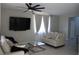 Bright living room with a comfortable seating area, a ceiling fan, and a large television at 7022 Judith River St, North Las Vegas, NV 89084