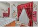 Cozy bathroom featuring a classic vanity and bright, unique red and white shower curtain at 7741 Fruit Dove St, North Las Vegas, NV 89084