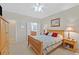 Comfortable bedroom featuring a wooden bed, ceiling fan, and access to the ensuite bathroom and walk-in closet at 7741 Fruit Dove St, North Las Vegas, NV 89084