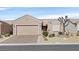 Charming single-story home featuring a two-car garage, desert landscaping, and a welcoming facade at 7741 Fruit Dove St, North Las Vegas, NV 89084