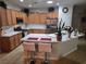 Well-lit kitchen featuring wooden cabinets, stainless steel appliances, and a spacious island with bar seating at 7741 Fruit Dove St, North Las Vegas, NV 89084