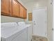 Functional laundry room with washer, dryer, and overhead cabinets for organized storage at 7741 Fruit Dove St, North Las Vegas, NV 89084
