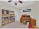 Well-lit office with white walls, carpet, built-in bookshelves, and a vintage desk at 7741 Fruit Dove St, North Las Vegas, NV 89084