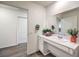 Bathroom with wood-look flooring, a white vanity with a large mirror, and an adjacent closet at 7910 Pandora Sky St # 271, North Las Vegas, NV 89084
