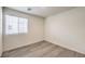 Bright bedroom featuring wood-look floors and a large window with blinds, creating a simple, airy space at 7910 Pandora Sky St # 271, North Las Vegas, NV 89084