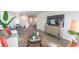 Bright living room featuring wood floors, modern furniture, a decorative rug, and a large television at 7910 Pandora Sky St # 271, North Las Vegas, NV 89084