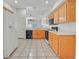 Kitchen featuring tan tile floor, light wood cabinets, and white appliances at 880 Autumn Canyon Way, Henderson, NV 89002