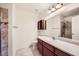 Bright bathroom featuring a cherry vanity, white countertop, framed mirror and tiled floors at 917 Pigeon Forge Ave, Henderson, NV 89015