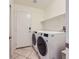 Laundry room with stainless steel washer and dryer and tile floors at 917 Pigeon Forge Ave, Henderson, NV 89015