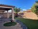 A modern backyard features mature trees, artificial turf, and covered patio at 953 Via Gandalfi, Henderson, NV 89011