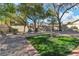 A backyard features multiple seating areas, landscaping, and a lush green lawn at 9768 Northern Dancer Dr, Las Vegas, NV 89117