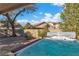 Hot tub with blue water sitting in a backyard with gravel and mature landscaping at 9768 Northern Dancer Dr, Las Vegas, NV 89117