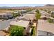 Aerial view of a community with tile roofs, mature landscaping, and beautiful mountain backdrop at 9807 Sage Canyon St, Las Vegas, NV 89178