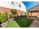 Charming backyard with artificial grass, brick-paved patio, and manicured landscaping at 9807 Sage Canyon St, Las Vegas, NV 89178