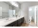Bathroom with a double sink vanity, a large mirror, and a separate toilet room at 9807 Sage Canyon St, Las Vegas, NV 89178