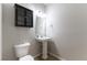 A clean and modern half-bath with pedestal sink and compact cabinet at 9807 Sage Canyon St, Las Vegas, NV 89178