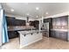 Spacious kitchen boasts dark cabinets, granite countertops, stainless steel appliances, and a center island at 9807 Sage Canyon St, Las Vegas, NV 89178