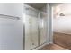Shower with glass doors and a tiled floor; view into an adjacent bedroom at 9807 Sage Canyon St, Las Vegas, NV 89178