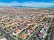 This aerial view captures many homes in a suburban neighborhood with views of distant mountains at 9967 Pipestone St, Las Vegas, NV 89141