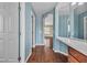 Hallway with blue-striped walls, hardwood floors, and an open door to the en-suite bathroom at 9967 Pipestone St, Las Vegas, NV 89141