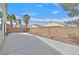 Fenced backyard with low maintenance landscaping, concrete patio, palm trees, and privacy at 100 Beaver Falls Ave, Las Vegas, NV 89123