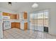 A bright kitchen features wooden cabinetry, modern appliances, and ample natural light from a sliding glass door at 100 Beaver Falls Ave, Las Vegas, NV 89123