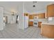 An open kitchen boasts wooden cabinets, a white appliance suite, and tile floors at 100 Beaver Falls Ave, Las Vegas, NV 89123