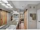 Bright bathroom with double sinks, sliding barn door, and wood-look flooring at 1012 Domnus Ln # 105, Las Vegas, NV 89144