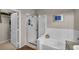 Modern bathroom with white tiled walls, glass shower, and soaking tub at 1012 Domnus Ln # 105, Las Vegas, NV 89144