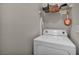 Practical laundry area with a washing machine and overhead storage shelves at 1012 Domnus Ln # 105, Las Vegas, NV 89144