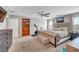 Bright main bedroom featuring a tufted headboard, exercise equipment, built-in bookshelves, and two windows at 10397 Skye Canyon Falls Ave, Las Vegas, NV 89166