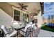 Relaxing covered patio with dining table, chairs, brick floor, and ceiling fan at 10397 Skye Canyon Falls Ave, Las Vegas, NV 89166