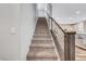 Carpeted staircase with modern metal railings and wooden accents, leading to the upper level of the home at 10397 Skye Canyon Falls Ave, Las Vegas, NV 89166