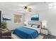 Bright bedroom with a ceiling fan, neutral walls, and a plush blue comforter at 1077 Lemongrass Ct, Henderson, NV 89002