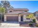 Charming two-story home featuring a tile roof, well-manicured landscaping, and a two-car garage, creating curb appeal at 1077 Lemongrass Ct, Henderson, NV 89002