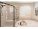 Bright bathroom featuring a tiled glass shower and a luxurious soaking tub for ultimate relaxation and comfort at 1301 Kingdom St, Las Vegas, NV 89117