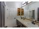 Bathroom with double sink vanity, framed mirrors, wood-look floors, updated lighting and large counter space at 1301 Kingdom St, Las Vegas, NV 89117