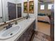 Bathroom with double sink vanity, framed mirrors, wood-look floors and doorway leading into bedroom with bed at 1301 Kingdom St, Las Vegas, NV 89117