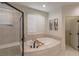 Relaxing bathroom featuring tiled glass shower and a luxurious soaking tub, perfect for a personal spa experience at 1301 Kingdom St, Las Vegas, NV 89117